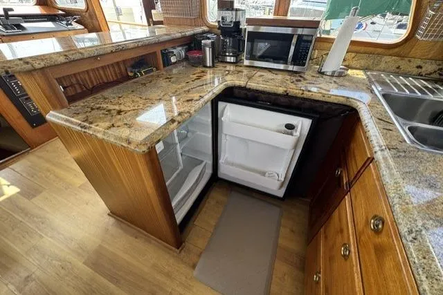 Slide: The Image of 1977 Californian 38 Motor Yacht kitchen with granite countertops, open fridge, and microwave. - 14