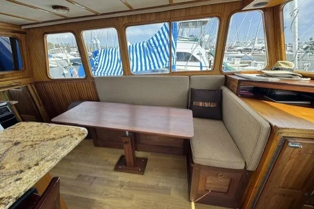 Slide: The Image of Interior of a 1977 Californian 38 Motor Yacht with wood paneling and a cozy dining area. - 10