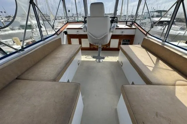 Slide: The Image of 1977 Californian 38 Motor Yacht interior with helm, cushioned seating, and marina view. - 45