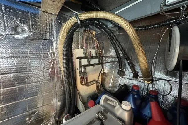 Slide: The Image of Engine room of a 1977 Californian 38 Motor Yacht with hoses and containers. - 26