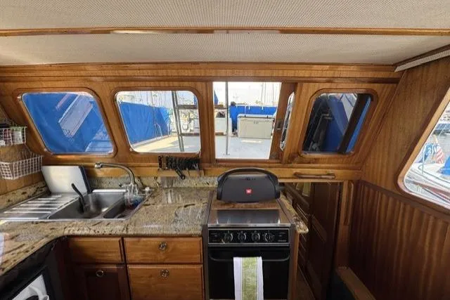 Slide: The Image of 1977 Californian 38 Motor Yacht kitchen with granite countertops and wooden cabinetry. - 15