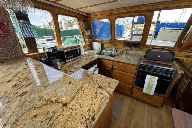 Slide: The Image of 1977 Californian 38 Motor Yacht kitchen with granite countertops and wooden cabinetry. - 12
