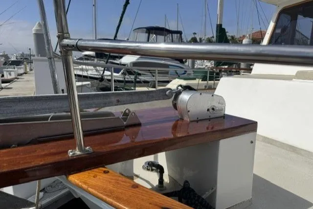 Slide: The Image of 1977 Californian 38 Motor Yacht deck with polished wood and metal railing at marina. - 2