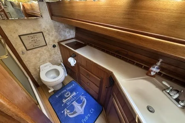 Slide: The Image of 1977 Californian 38 Motor Yacht bathroom with wooden cabinetry and nautical-themed decor. - 34