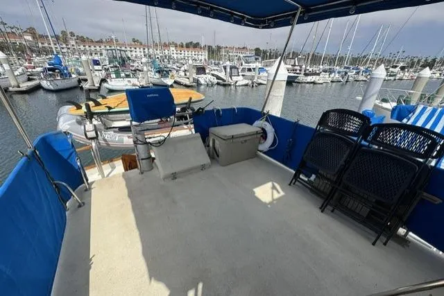 Slide: The Image of 1977 Californian 38 Motor Yacht docked at marina, featuring spacious deck and seating area. - 44
