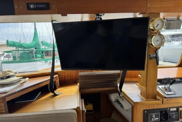 Slide: The Image of 1977 Californian 38 Motor Yacht interior with TV, wooden cabinetry, and nautical instruments. - 51