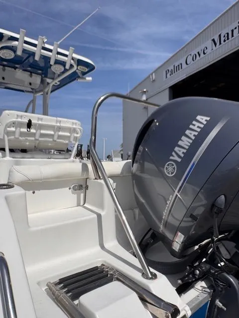 Slide: The Image of A 2018 Sea Hunt 234 SXS boat with a Yamaha outboard motor, situated at a marina. - 6