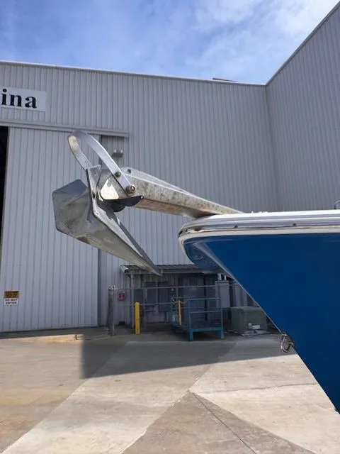 Slide: The Image of Bow of a blue boat with an anchor in front of a building. - 9