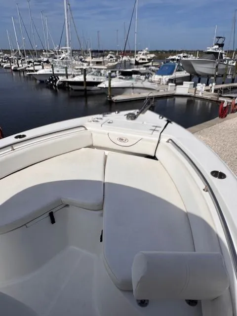 Slide: The Image of The image shows the bow seating area of a Sea Hunt 234 SXS boat in a marina. - 18
