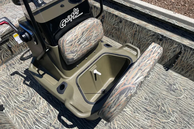 Slide: The Image of 2026 Tracker Grizzly 1860 CC boat interior with camo seats and storage compartment. - 10