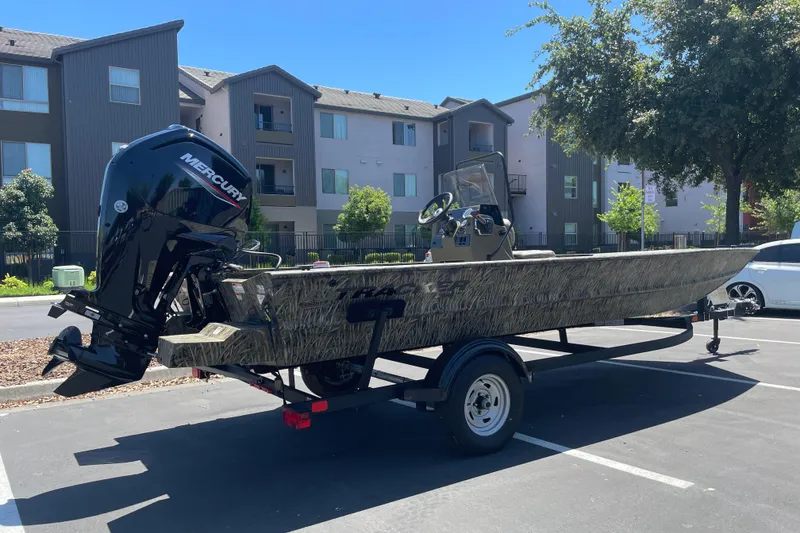 Slide: The Image of 2026 Tracker Grizzly 1860 CC boat with Mercury engine in a parking lot. - 3
