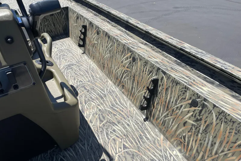 Slide: The Image of 2026 Tracker Grizzly 1860 CC boat interior with camouflage design and control panel. - 13