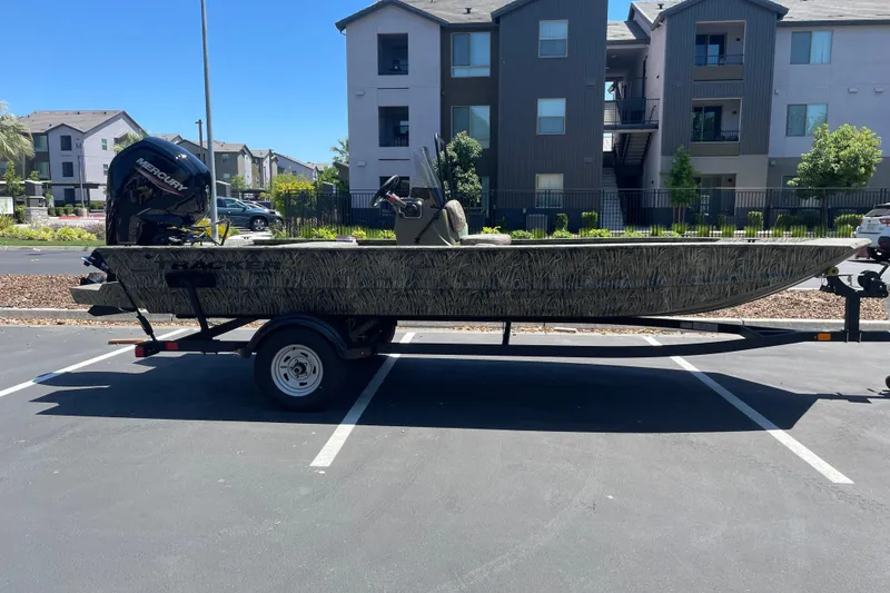 The Image of 2026 Tracker Grizzly 1860 CC boat on trailer in parking lot. - 0