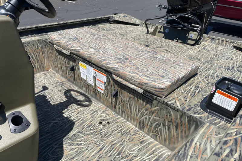 Slide: The Image of 2026 Tracker Grizzly 1860 CC boat interior with camouflage seating and safety labels. - 5