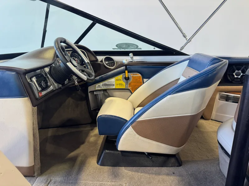 Slide: The Image of Interior of a 2010 Nautique Ski Nautique 200 with blue and white seats and steering console. - 21