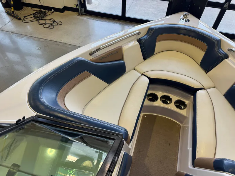 Slide: The Image of The image shows the bow of a 2010 Ski Nautique 200 with blue and white upholstery. - 17