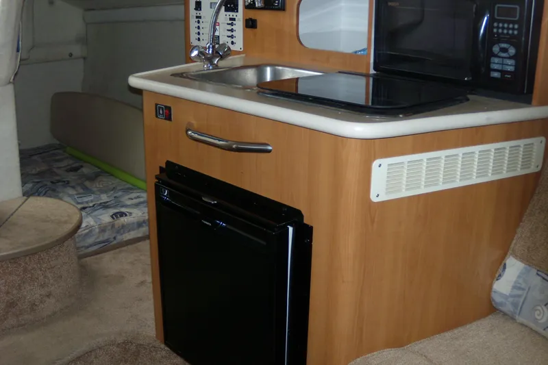 Slide: The Image of 2002 Bayliner 2455 Ciera cabin interior with kitchenette, sink, and compact appliances. - 13