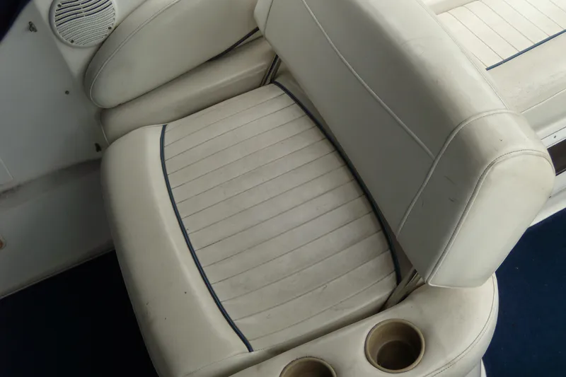 Slide: The Image of White leather seating on a 2002 Bayliner 2455 Ciera boat, featuring cup holders. - 7