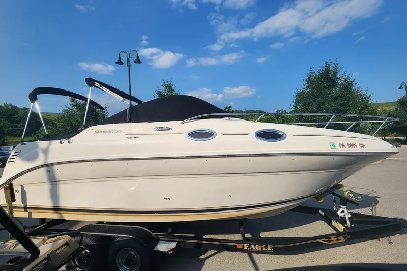 Slide: The Image of 2003 Sea Ray 240 Sundancer boat on trailer under clear blue sky. - 0