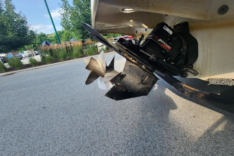 Slide: The Image of 2003 Sea Ray 240 Sundancer boat propeller and engine detail in a parking lot. - 10