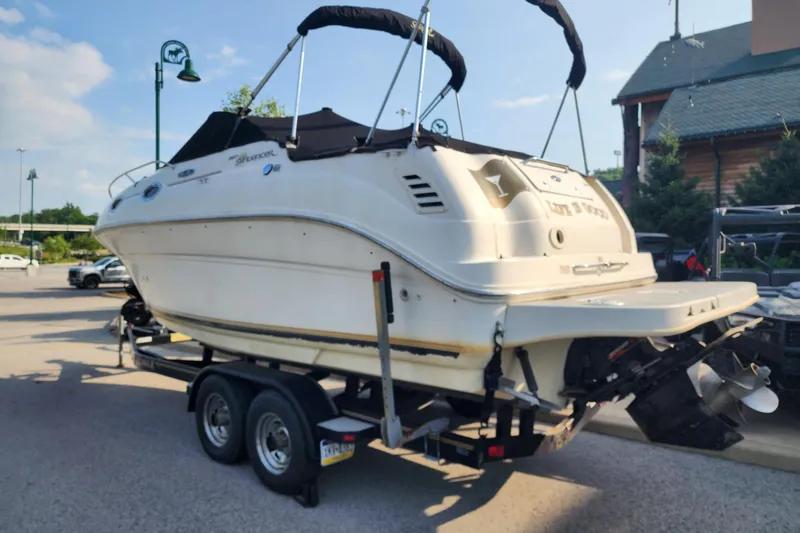 Slide: The Image of 2003 Sea Ray 240 Sundancer boat on trailer in parking lot, sunny day. - 2