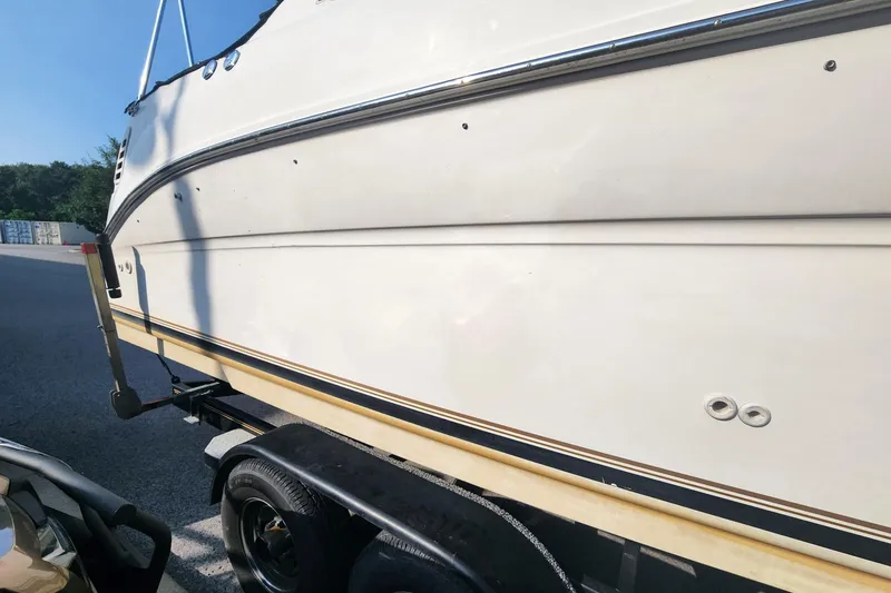 Slide: The Image of 2003 Sea Ray 240 Sundancer boat on trailer, side view, outdoors. - 8
