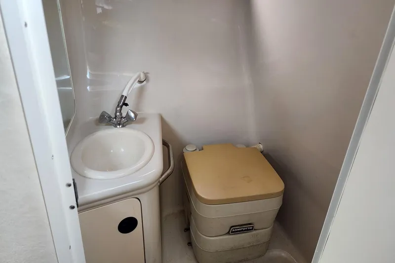 Slide: The Image of Compact bathroom in 2003 Sea Ray 240 Sundancer boat with sink and portable toilet. - 18