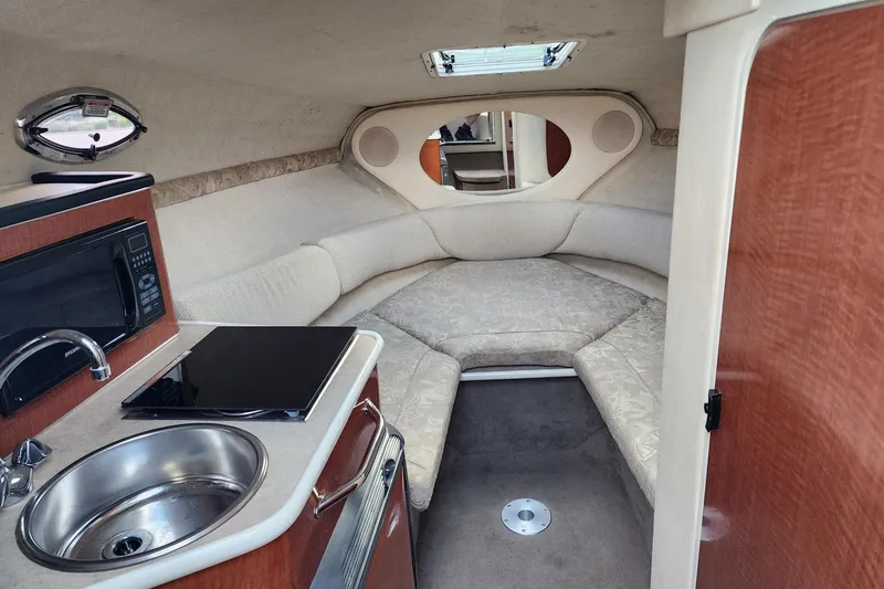 Slide: The Image of Interior of 2003 Sea Ray 240 Sundancer boat with kitchenette and cozy seating area. - 17