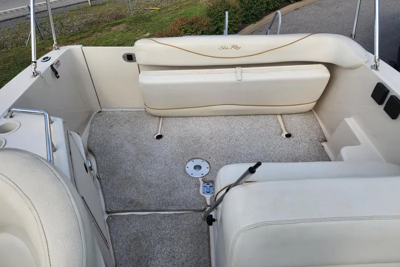 Slide: The Image of Interior of a 2003 Sea Ray 240 Sundancer boat with beige seating and carpeted floor. - 19