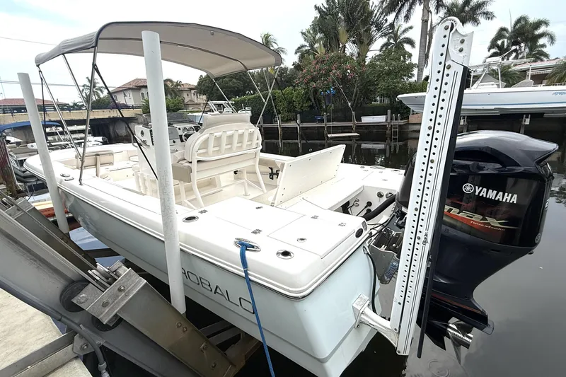 Slide: The Image of 2016 Robalo 246 Cayman boat with Yamaha engine docked near lush greenery. - 6