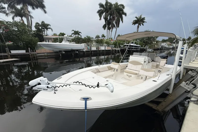 Slide: The Image of 2016 Robalo 246 Cayman boat docked in a scenic canal with palm trees. - 1