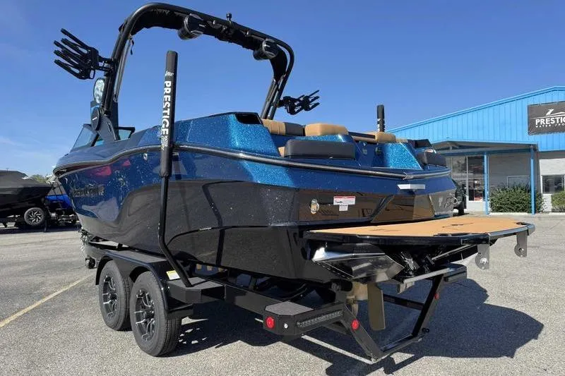 Slide: The Image of 2026 MasterCraft XT23 boat on trailer, blue exterior, parked outdoors. - 8