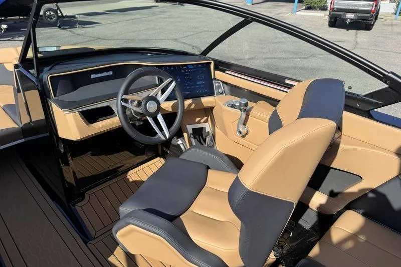 Slide: The Image of Interior of 2026 MasterCraft XT23 boat with modern dashboard and tan seating. - 10