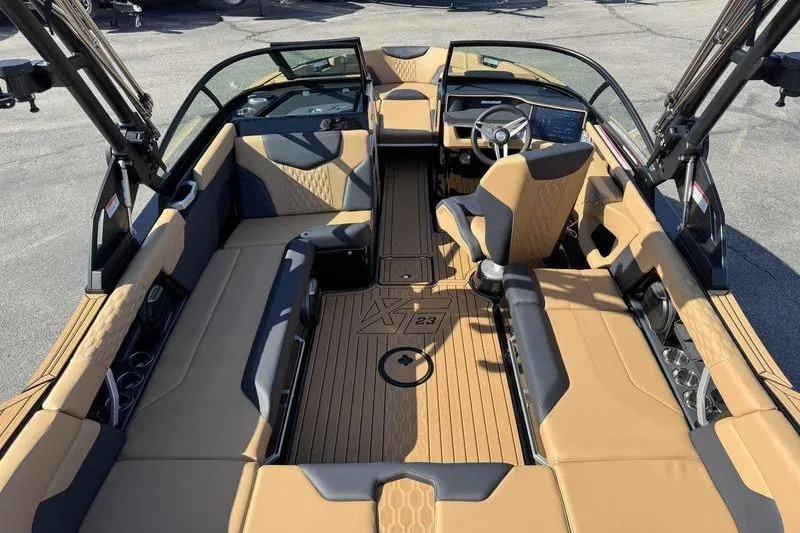 Slide: The Image of 2026 MasterCraft XT23 boat interior with tan and black seating, sleek design, and modern dashboard. - 9