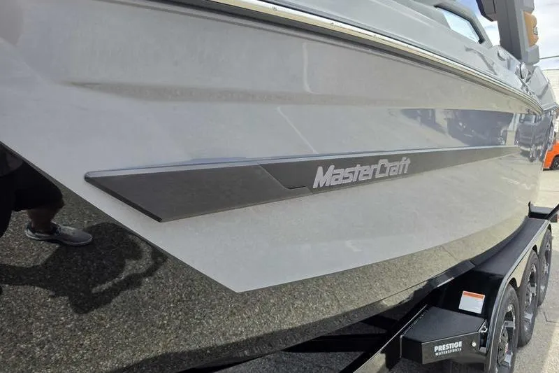 Slide: The Image of 2027 MasterCraft X23 boat on trailer, showcasing sleek design and branding. - 7