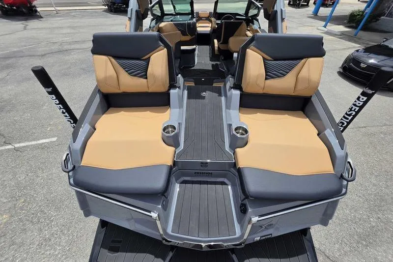 Slide: The Image of 2027 MasterCraft X23 boat interior with tan and gray seating, cup holders, and sleek design. - 8