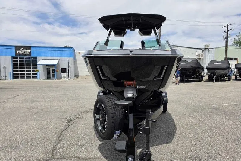 Slide: The Image of 2027 MasterCraft X23 boat on trailer in dealership parking lot. - 1