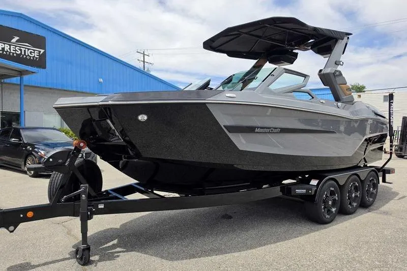 Slide: The Image of 2027 MasterCraft X23 boat on trailer at dealership, showcasing sleek design and modern features. - 12