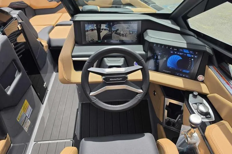 Slide: The Image of Interior of a 2027 MasterCraft X23 boat featuring advanced dashboard and steering wheel. - 2