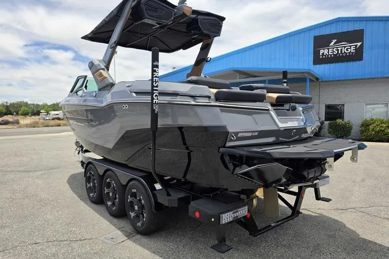 Slide: The Image of 2027 MasterCraft X23 boat on trailer at Prestige Water Sports dealership. - 11