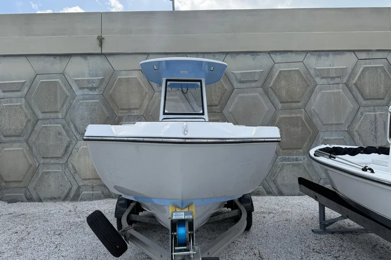 The Image of 2024 Yamaha Boats 222 FSH Sport E on trailer, parked against hexagonal wall. - 1