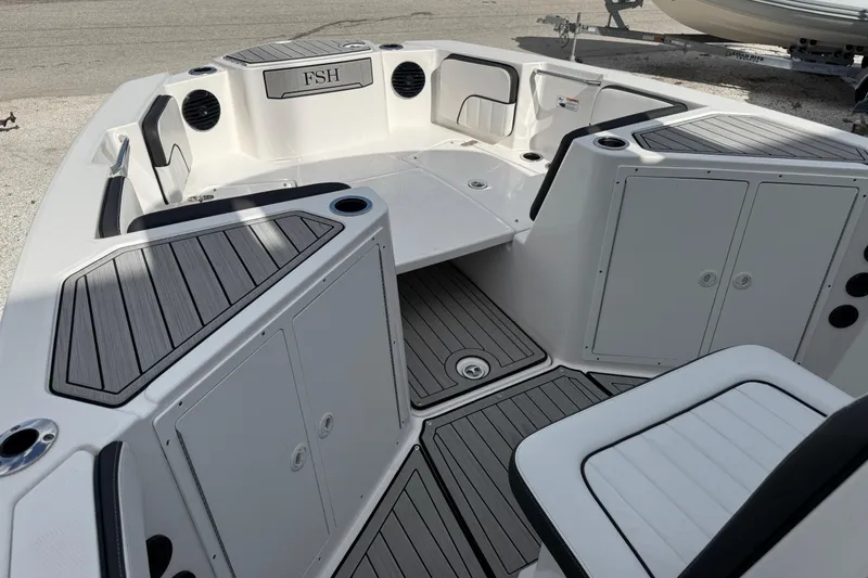 Slide: The Image of 2024 Yamaha Boats 222 FSH Sport E interior with sleek seating and storage compartments. - 7