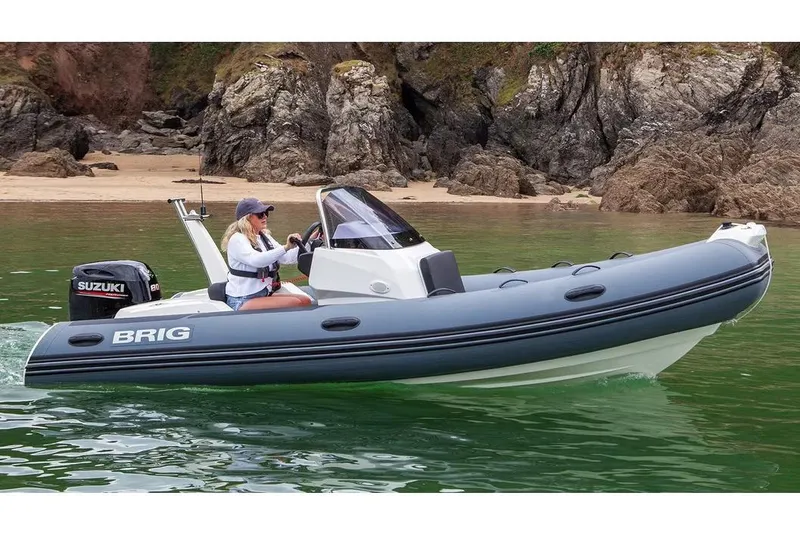 The Image of Manufacturer Provided Image: 2026 Brig Eagle 5 boat cruising near rocky shoreline with Suzuki engine. - 0