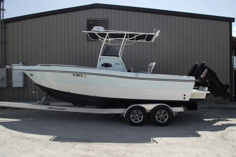 The Image of 2018 Caravell Key Largo 2486WI boat on trailer, parked outside a building. - 0