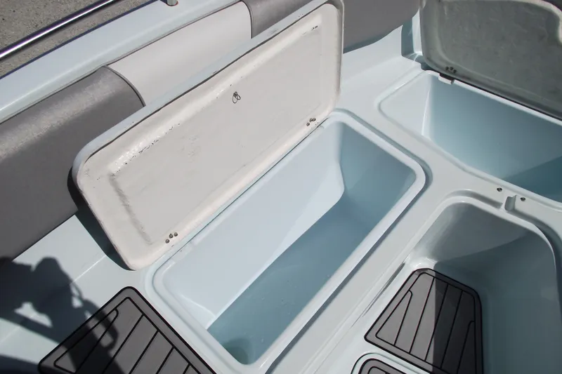 Slide: The Image of 2018 Caravell Key Largo 2486WI boat storage compartments with open lids and non-slip flooring. - 7