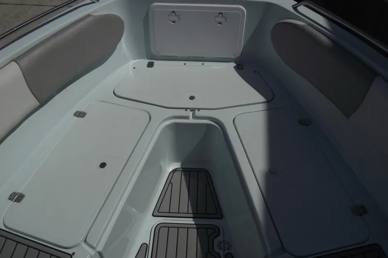 Slide: The Image of 2018 Caravell Key Largo 2486WI boat interior with storage compartments and cushioned seating. - 6