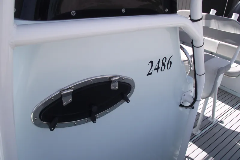 Slide: The Image of 2018 Caravell Key Largo 2486WI boat interior with porthole and seating. - 16