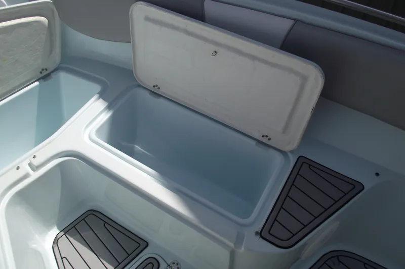 Slide: The Image of 2018 Caravell Key Largo 2486WI boat storage compartments with open lids. - 9