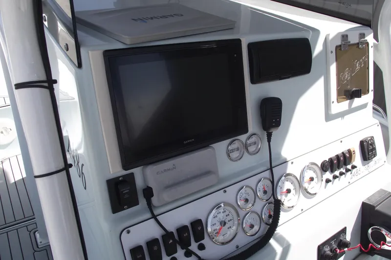 Slide: The Image of 2018 Caravell Key Largo 2486WI boat dashboard with Garmin display and control gauges. - 22