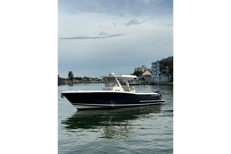 Slide: The Image of 2015 Belzona 32 Cuddy boat on calm water, with modern design and sleek profile. - 1